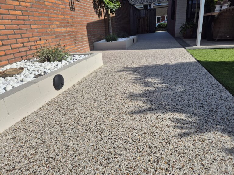Tuinpad van harsgebonden grind langs de gevel, aangelegd door Step Stones